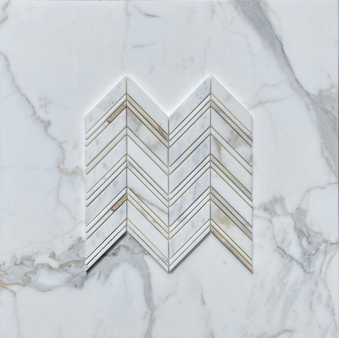 Italian Calacatta Gold marble tile samples arranged in a chevron pattern on white marble background.