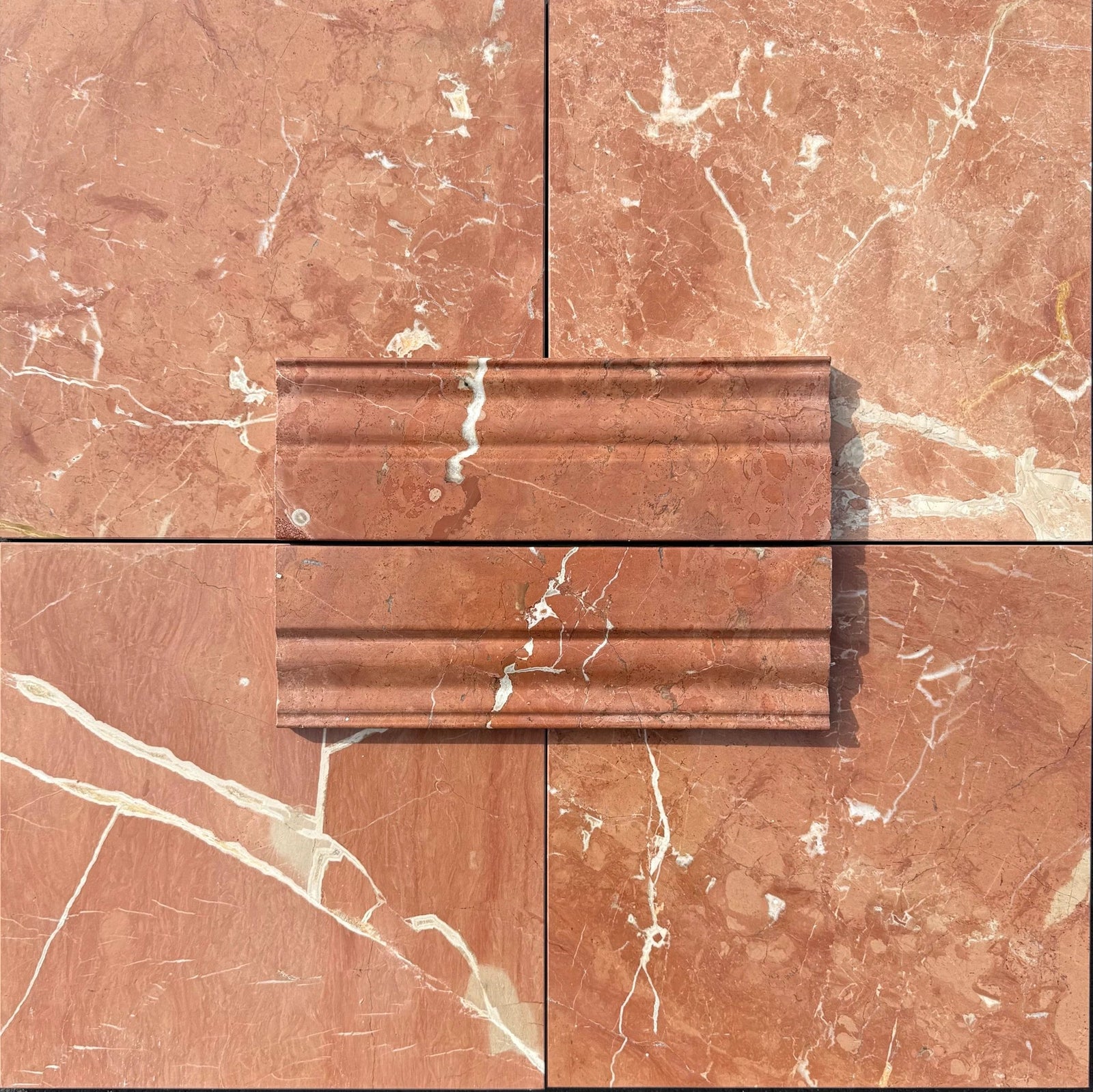 Rojo Alicante marble baseboard molding on red-veined marble tiles; Tilehouz