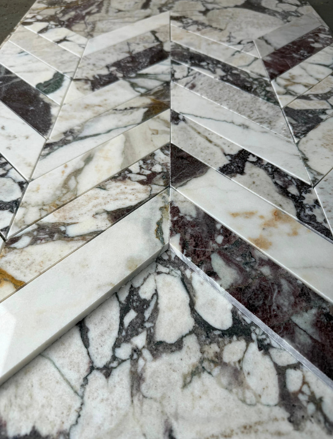 Calacatta Viola marble 2x8 chevron mosaic tile by Tilehouz for walls, white with purple veining