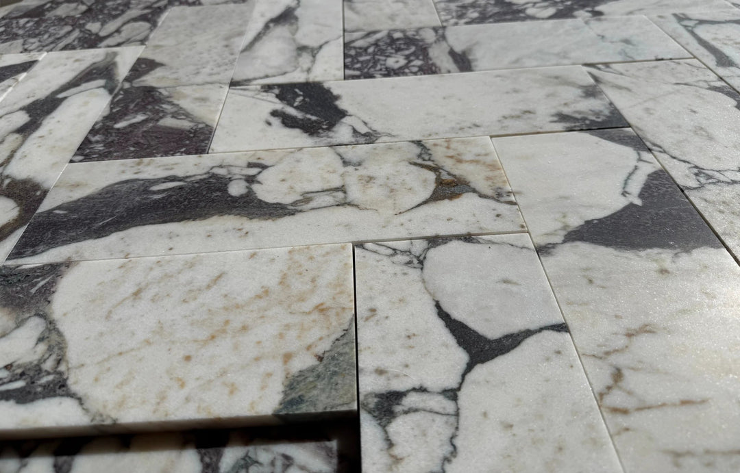 Calacatta Viola marble tile 4x12 by Tilehouz; white with dark gray veining, set of stacked tiles.