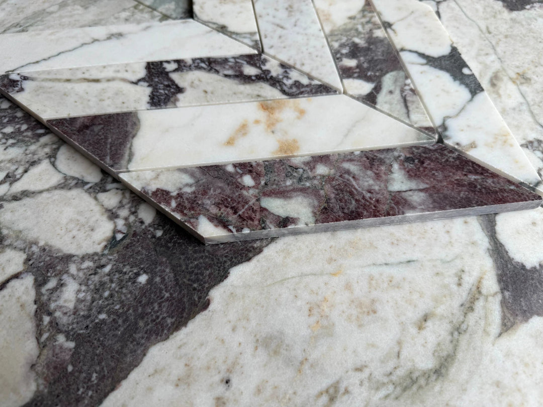 Tilehouz Calacatta Viola marble 2x8 chevron mosaic sheet, white with purple-gray veining.