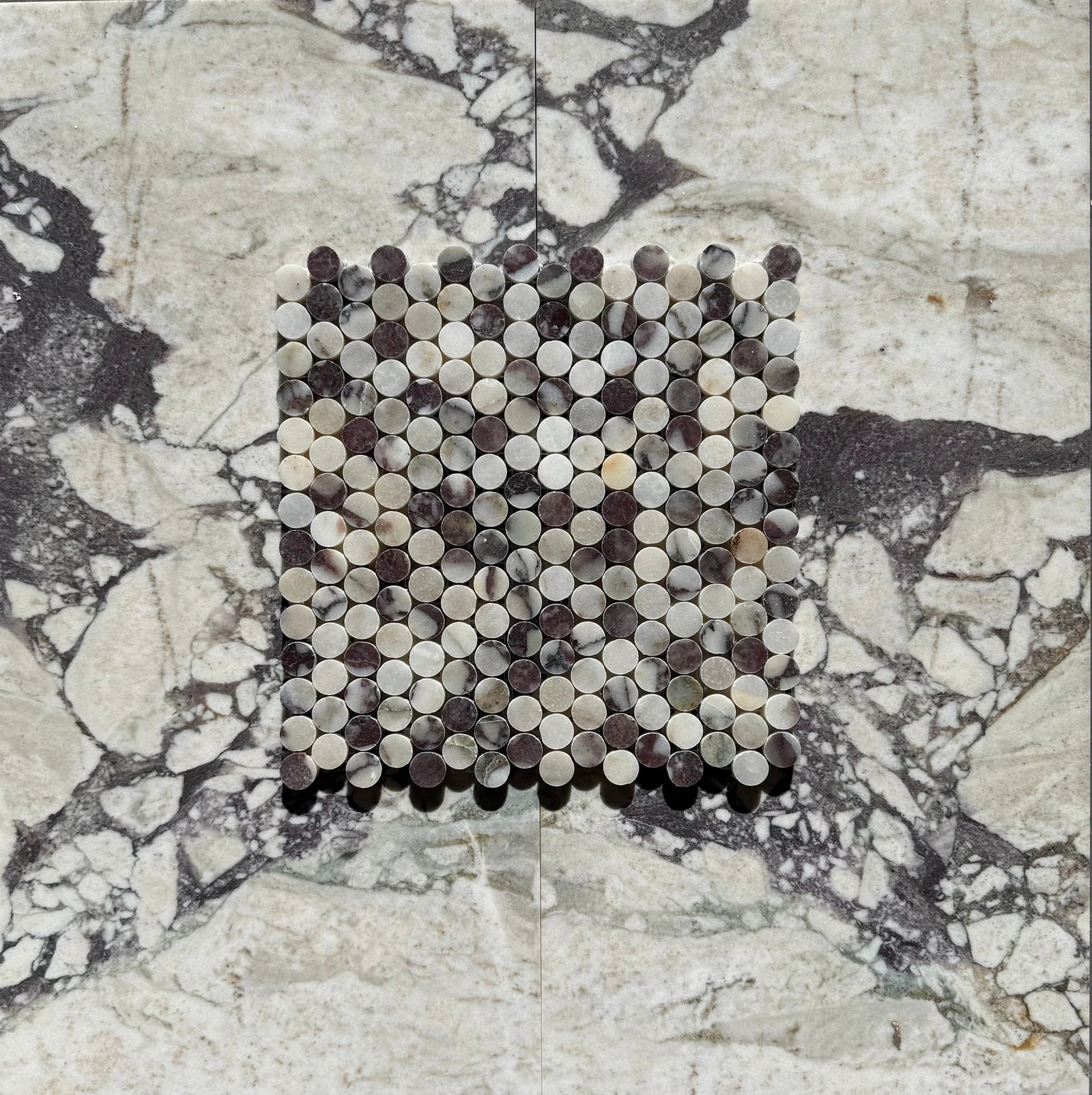 Calacatta Viola marble penny mosaic by Tilehouz; round discs in white, cream, gray, and purple