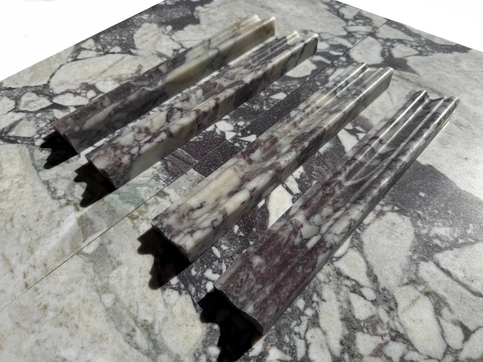 Calacatta Viola marble Milano chair-rail samples, 2x12, five pieces with white, gray and purple veining.