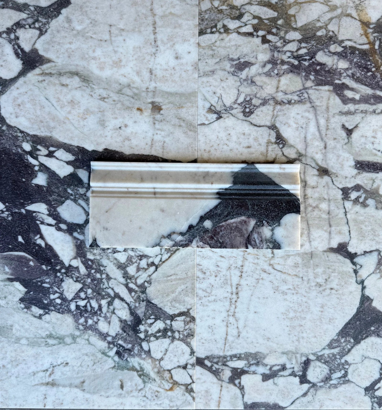 Calacatta Viola marble baseboard by Tilehouz, white with purple veining, beveled profile.