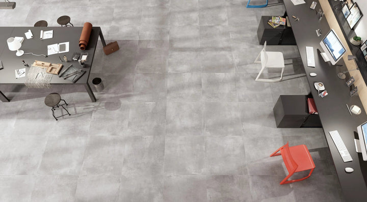 Volcano Grey porcelain tile 12x24 by Tilehouz; gray cement-like finish in a modern office workspace.