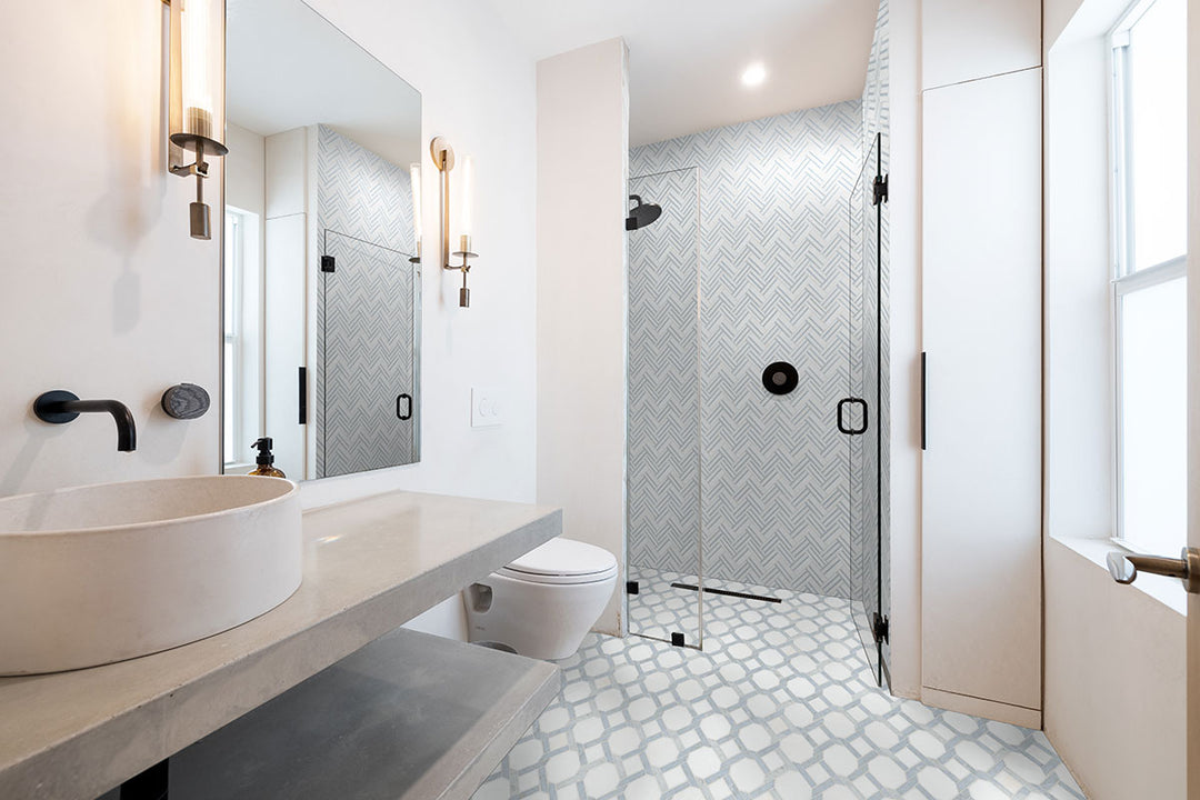 Azula Linea Polished Mosaic marble tile sheet; light blue-gray herringbone shower wall tiles in a modern bathroom.