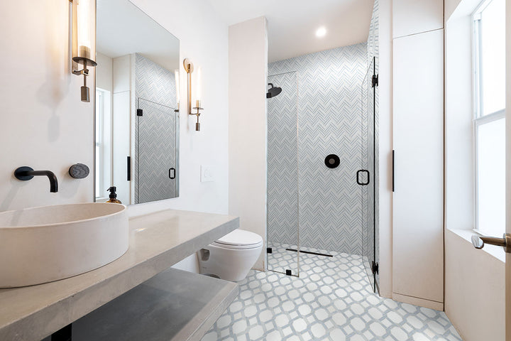 Azula Linea Polished Mosaic marble tile sheet; light blue-gray herringbone shower wall tiles in a modern bathroom.