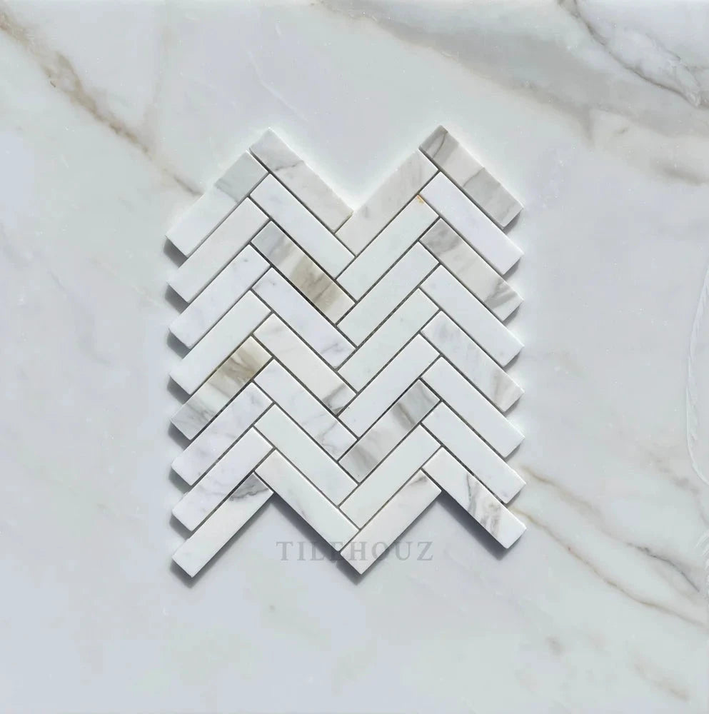 Calacatta Gold marble 1x4 herringbone mosaic tile by Tilehouz, white with gray veining, polished & honed