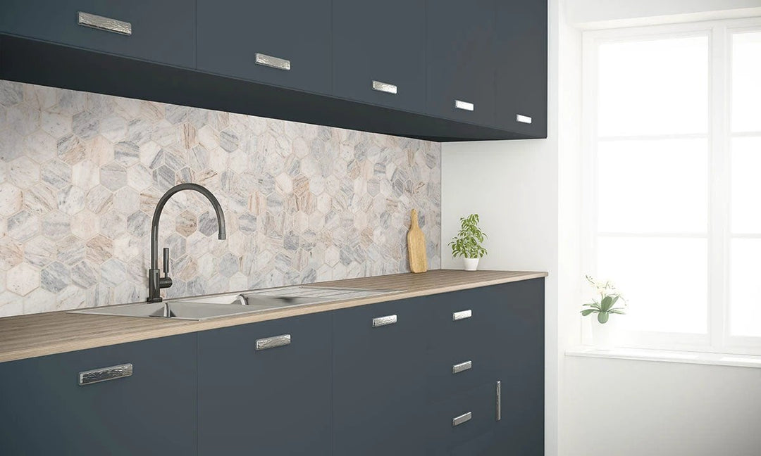 Capri Blue Marble Honed 2" Hexagon Mosaic gray-white marble wall tile backsplash in a kitchen with dark navy cabinets.
