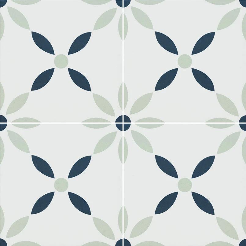 Zaria Greta 8x8 encaustic-look porcelain tiles; four tiles show navy blue and sage-green floral motifs on light background.