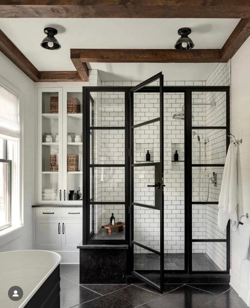 Pierre Bleu limestone 12x24 brushed tile for walls and ceilings; shown in a bathroom with a black-framed glass shower.