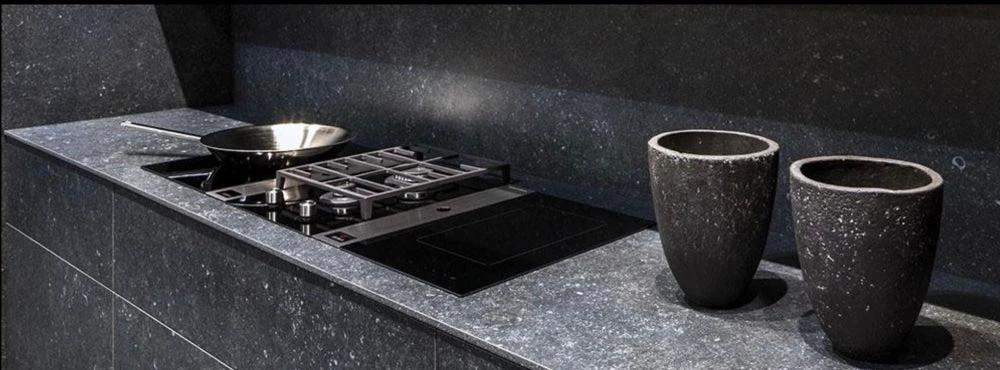 Pierre Bleu Belgian Bluestone limestone 12x24 brushed tile on a dark kitchen countertop with stove and two dark cups